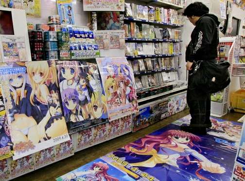 Un homme regardes des jeux vidéo dans une boutique de Tokyo